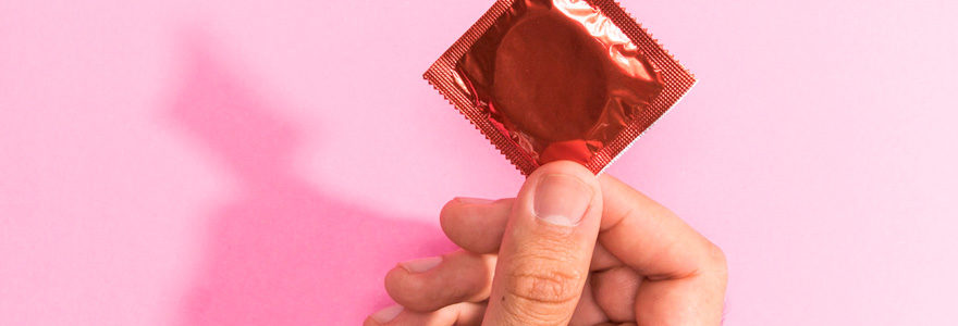 close-up-man-holding-up-red-condom